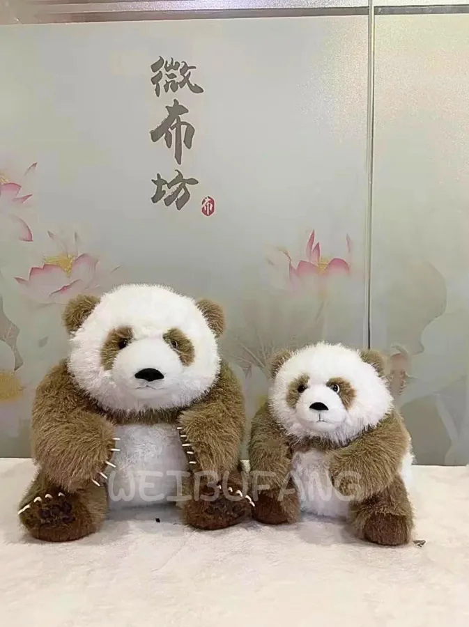 Two panda plush toys in coordinated brown outfits.